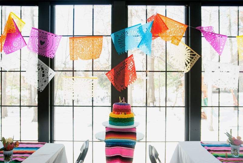rainbow cake and papel picado garland at fiesta party