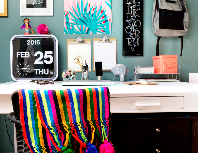 Add pops of brights to your home office, like a striped blanket and unique art prints!